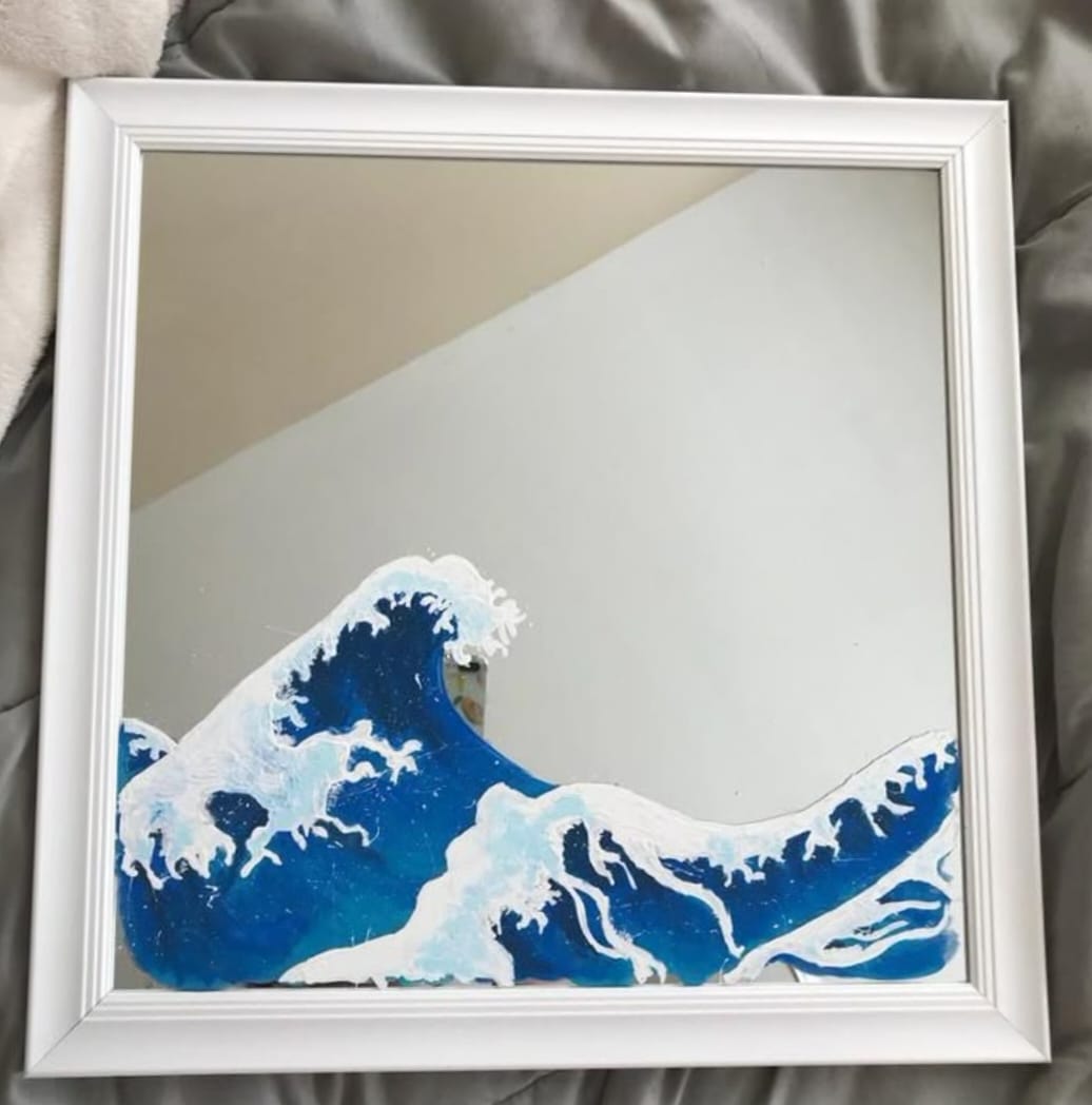 Framed artwork of a blue wave on a neutral background