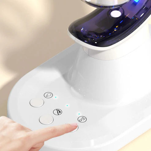 Hand pressing a button on a white electronic device with control buttons.