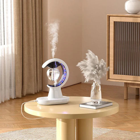 Tabletop humidifier emitting mist on a wooden table with decorative elements in a room.
