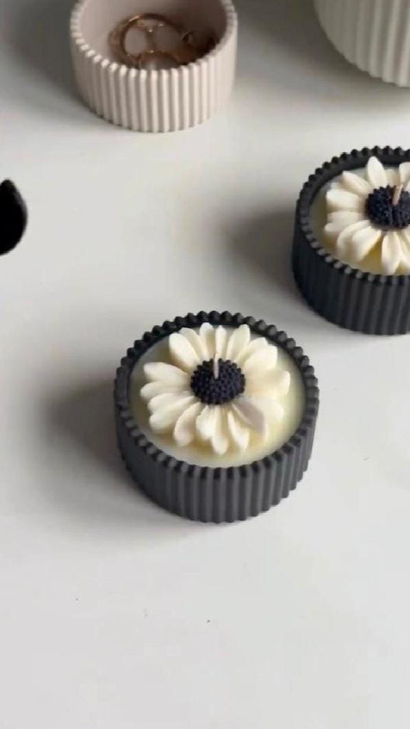 Candle with flower design on a white surface