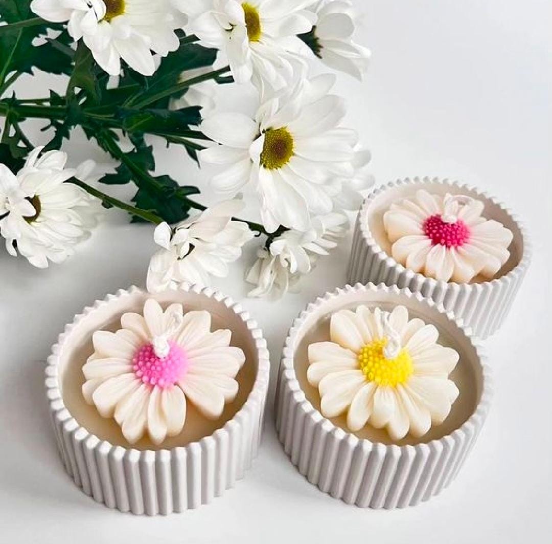 Cupcakes with floral designs on a white surface with flowers in the background