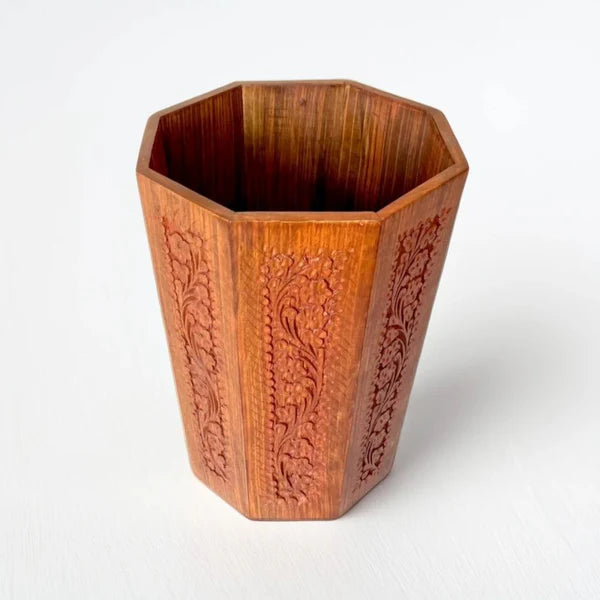 Wooden vase with intricate carvings on a white background