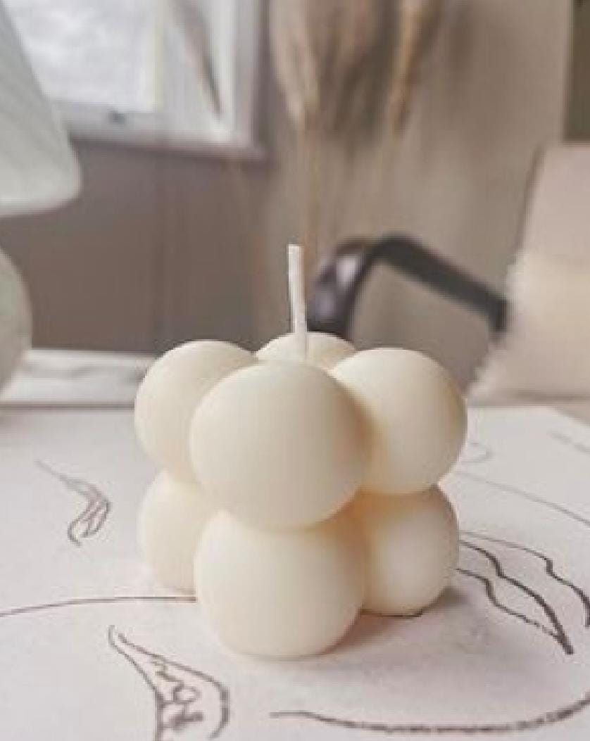 White spherical candles on a textured surface with a blurred background