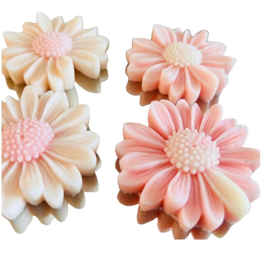 Four pink and white flower-shaped objects on a white background