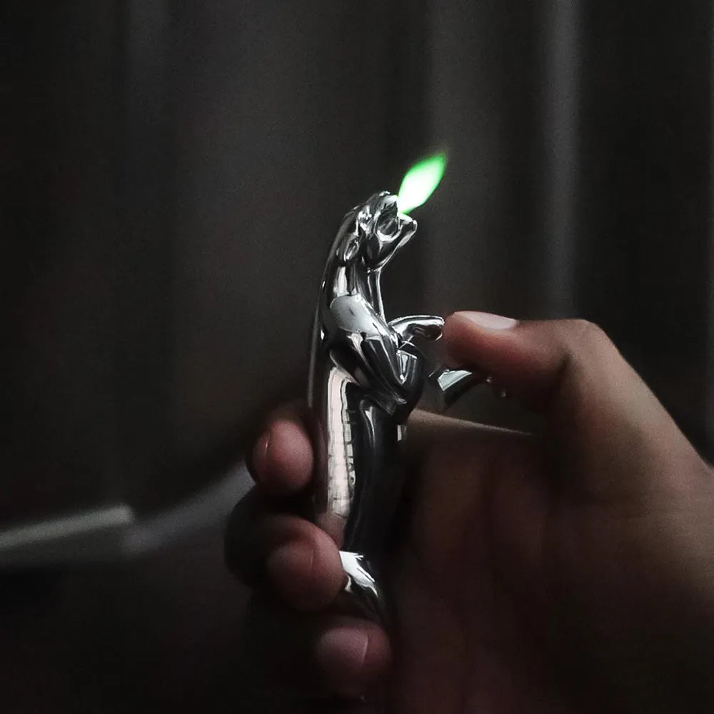 Hand holding a car emblem lighter with a lit flame against a dark background