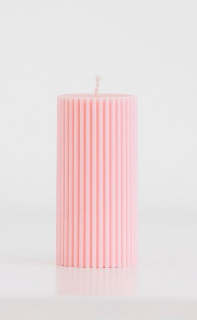 Pink cylindrical candle on a light gray background