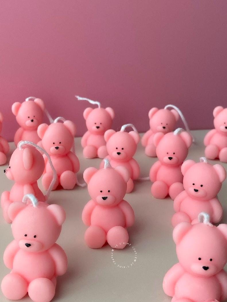 Pink teddy bear-shaped candles on a pink background