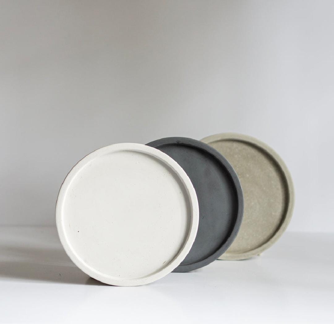 Three ceramic containers with lids in white, gray, and beige on a light gray background