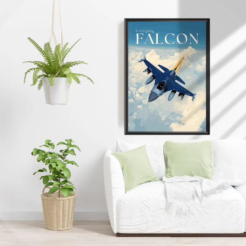 Framed poster of a blue fighter jet labeled 'Falcon' above a white couch with green pillows.