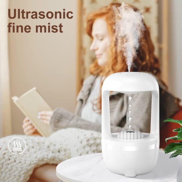 Woman reading a book with an ultrasonic humidifier emitting mist in the foreground.