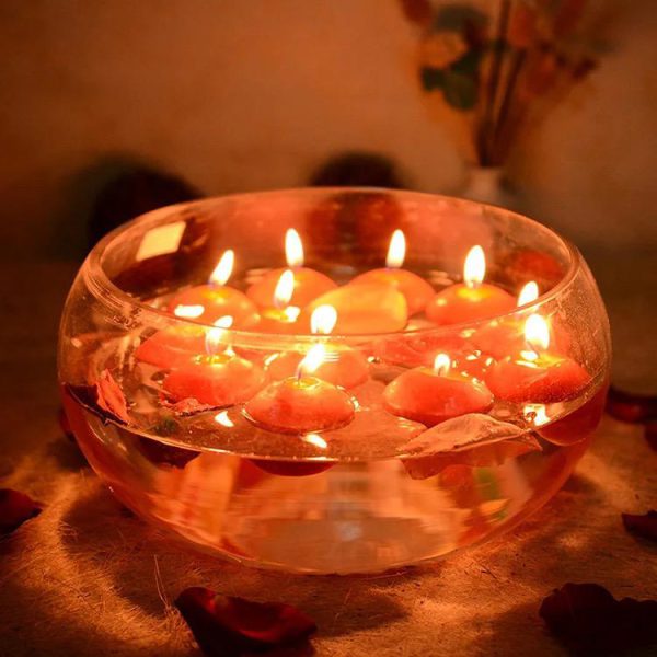 Glass bowl with floating candles on a soft background