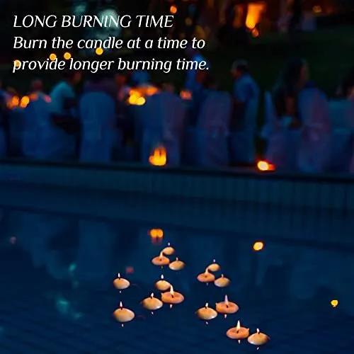 Candles floating on water with a blurred background of people and lights.