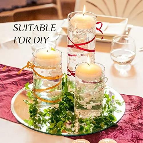 Decorative candles with ribbons on a table with a red tablecloth