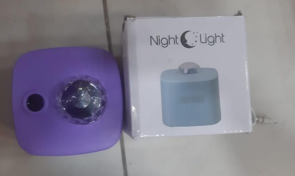 Purple night light and its packaging on a tiled floor