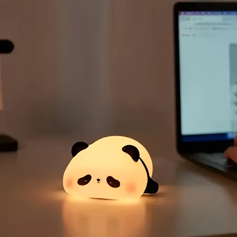 Panda-shaped night light on a desk with a computer in the background