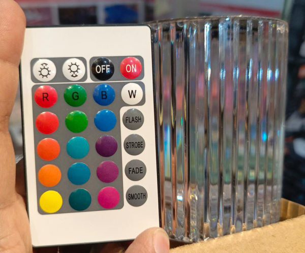 Color wheel and remote control held by a hand with a blurred background
